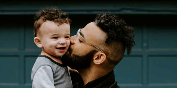 Father kissing son on cheek