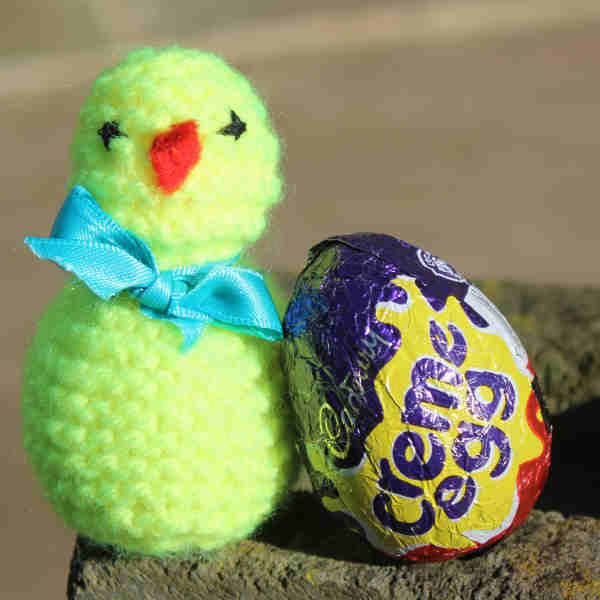 A knitted chick with a creme egg